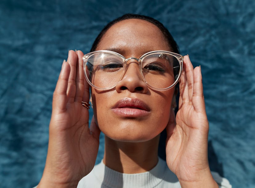 Young woman with big glasses studying the astrology elements and their meanings.