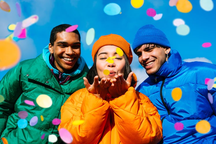 group of young friends blow confetti into the camera as they consider how the January 2024 Full Wolf...